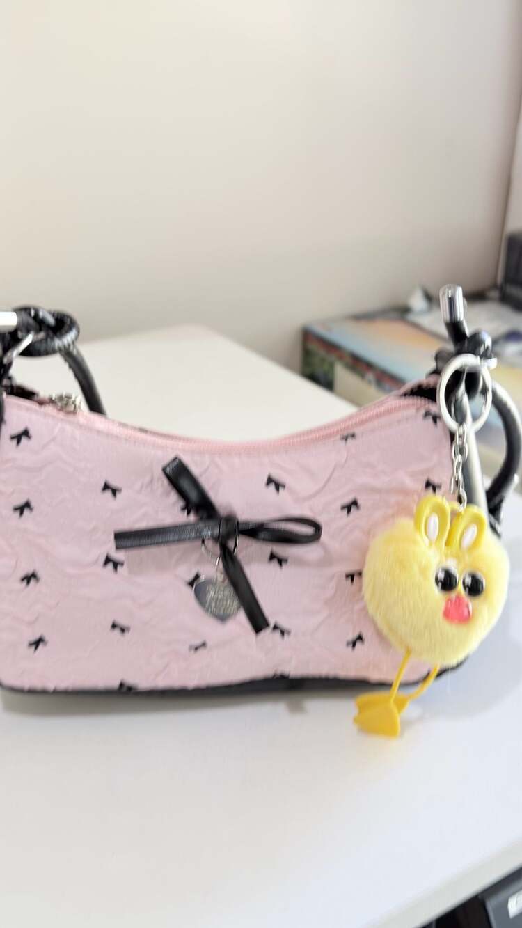 Pink Textured Crescent Shoulder Bag with Black Bow Pattern and Heart Charm